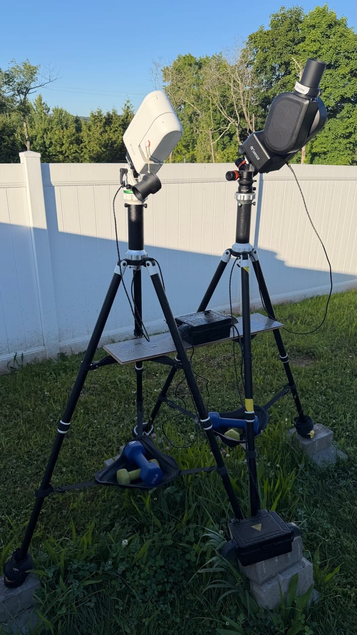 Two Seestar telescopes on tripod-mounted backyard rigs in daylight.