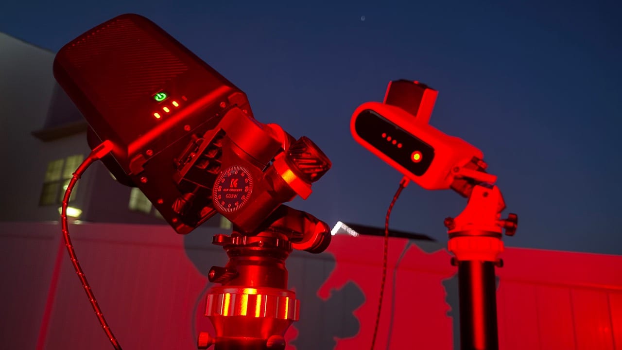 Two Seestar telescopes set up at night under red field light.